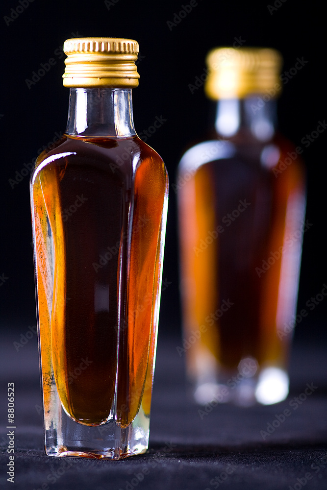 two whiskey bottles on black background