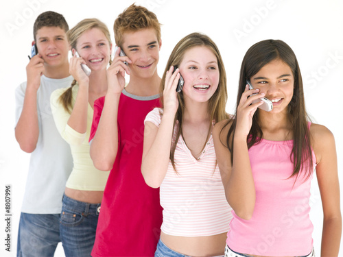 Row of five friends on cellular phones smiling