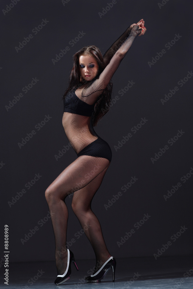 cute young female in lingerie posing on a dark background