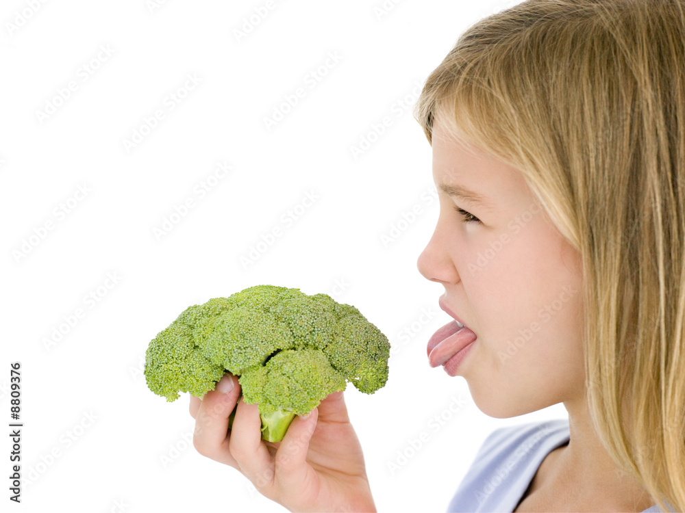 Young girl holding broccoli and sticking tongue out Young girl holding broccoli and sticking tongue out