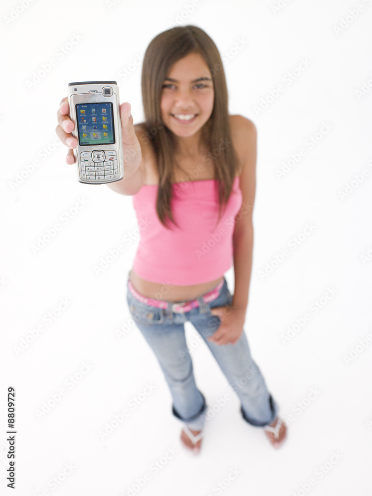 Teenage girl using celcular phone and smiling Teenage girl using celcular phone and smiling