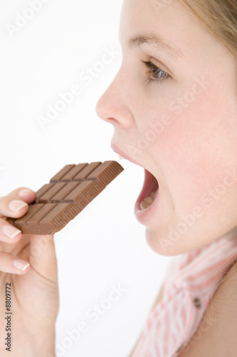 Teenage girl eating chocolate bar
