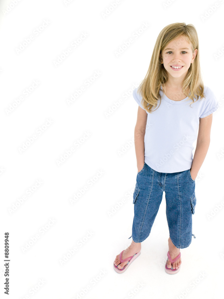 Young girl with hands in pockets smiling Young girl with hands in pockets smiling