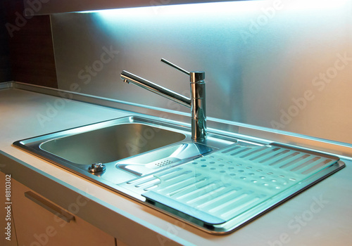 Modern stainless steel tap in white kitchen photo