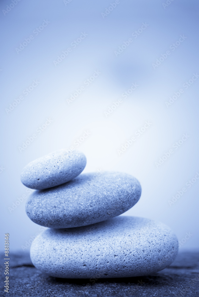 pebbles stacked on a rock - blue background pebbles stacked on a rock - blue background