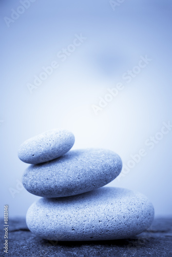 pebbles stacked on a rock - blue background
