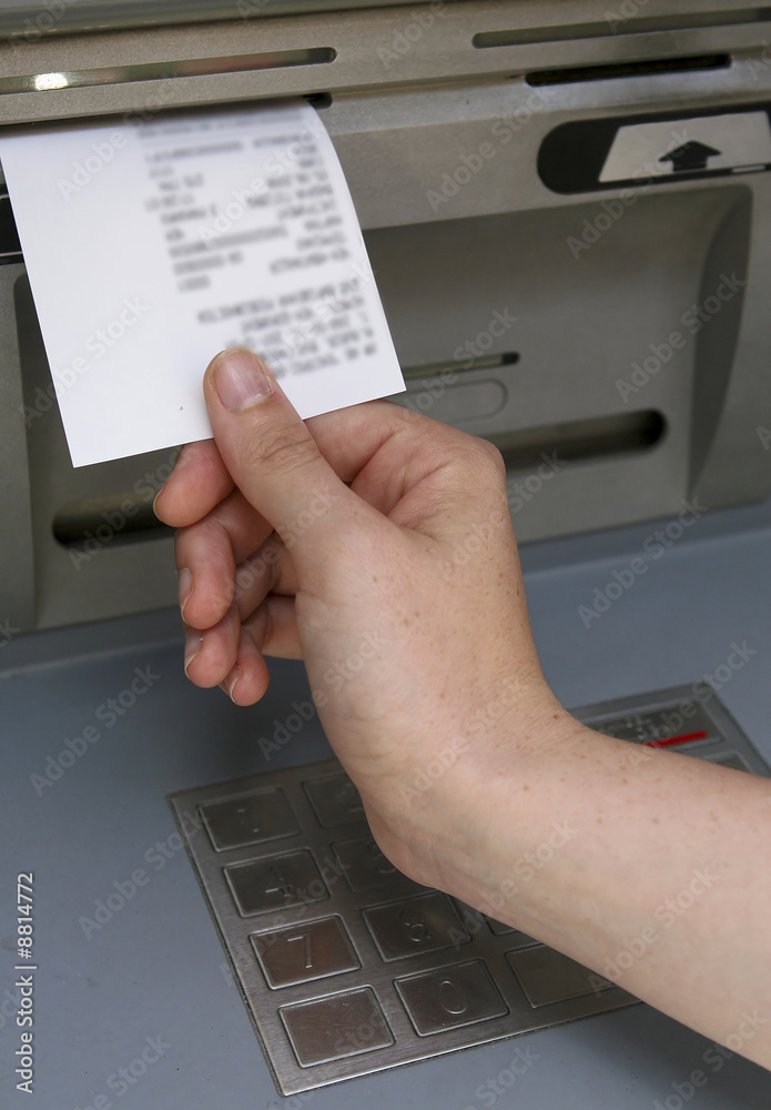 Hand taking a receipt of an Automated Teller Machine Hand taking a receipt of an Automated Teller Machine