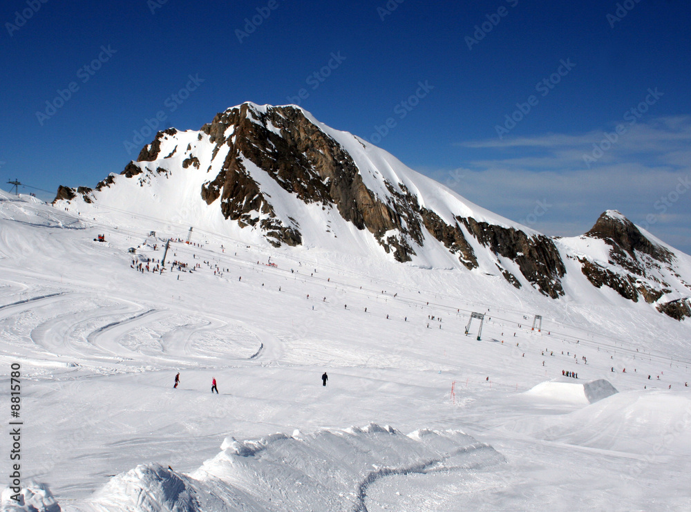 Skiers on mountainside in Swiss Alps scenery.