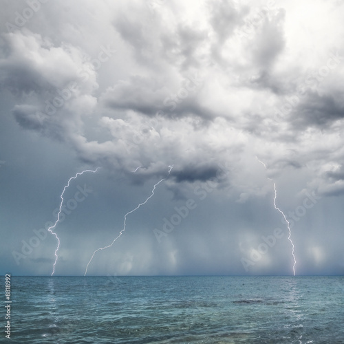 Lightning and thunderstorm above sea in the day