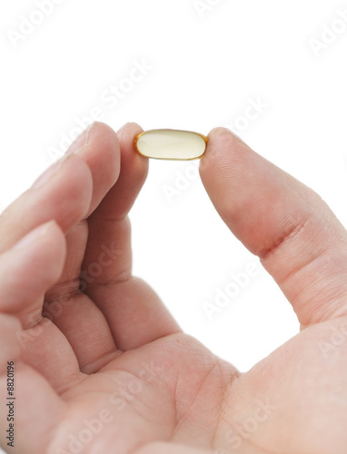 Omega 3 fish oil capsule held by a hand