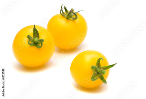 three yllow tomatoes on white background