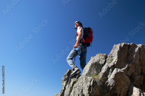 Climber standing on a stone at the top of his route