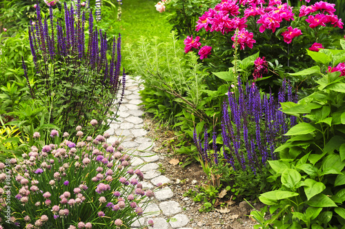 Lush blooming summer garden with paved path #8837318
