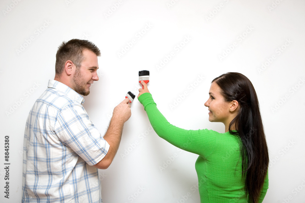 happy casual couple painting wall happy casual couple painting wall