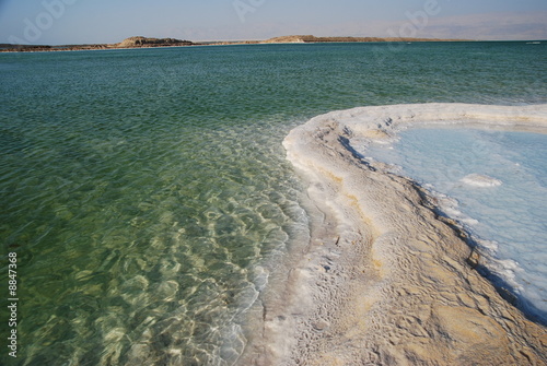 Salt on dead sea in the rays of sunset by evening