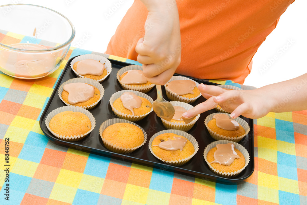 Fototapeta premium Child icing fairy cakes, close up and angled