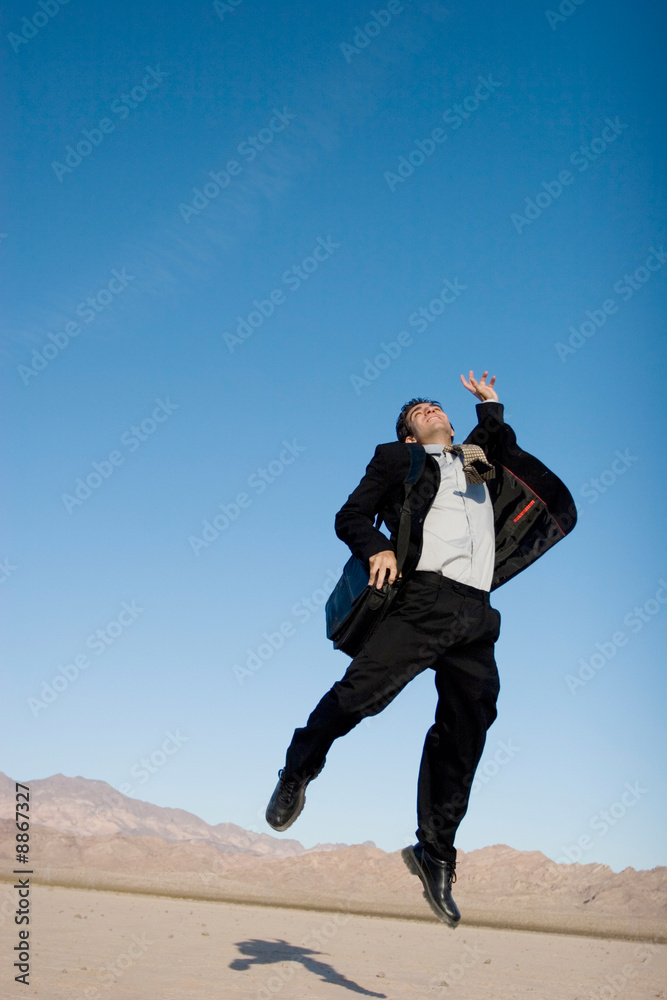 Ecstatic business man jumping in the air