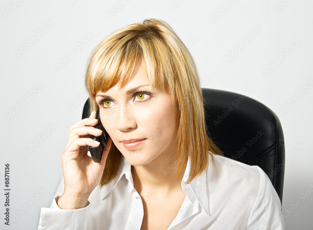 Young beautiful business lady on a chair speaking by phone. Young beautiful business lady on a chair speaking by phone.