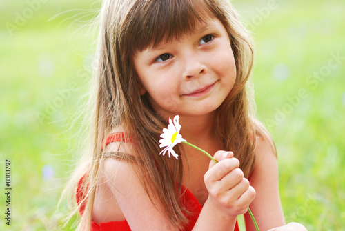 Little cute girl with flower outdoors