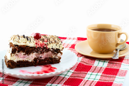 Piece of cake on white plate and  cup of tea