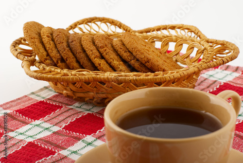 Biscuits in the straw basket and a cup of tea