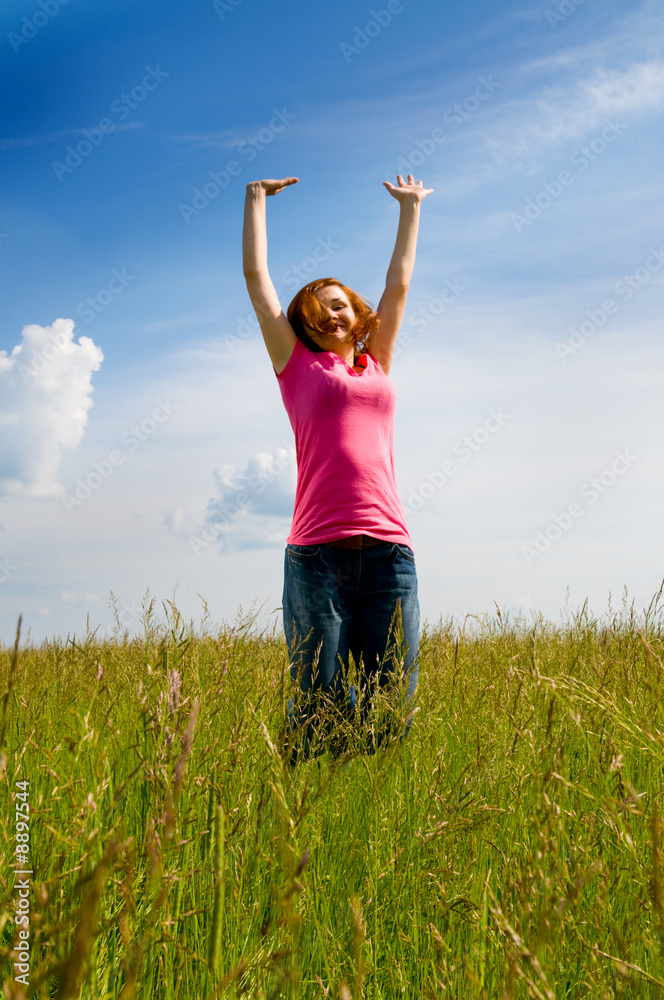 beautiful spreading her arms in the middle of a field. beautiful spreading her arms in the middle of a field.