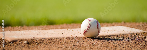 Photo A white leather baseball lying on top of the pitcher's mound