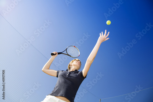 blond woman playing tennis, about to hit the ball. Copy space © Diego Cervo