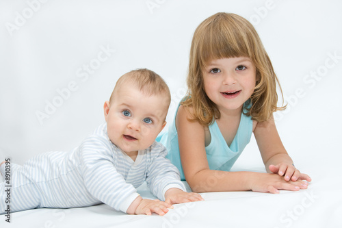 little brother and sister playing together, on white