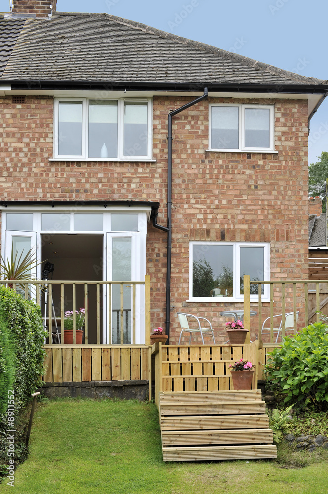 Obraz premium house with wooden decking and patio leading to garden