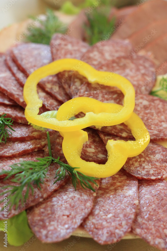 Slices of salami decorated with pepper rings, close-up
