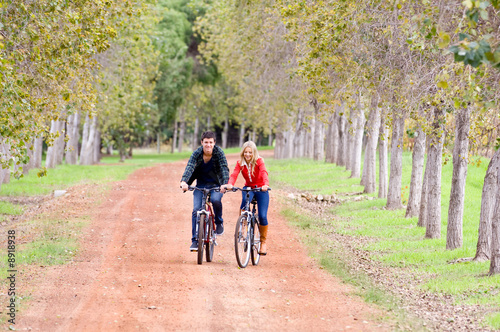 A young couple on bikes in a country lane