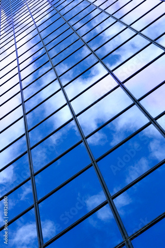 Glass wall of business center and sky reflection