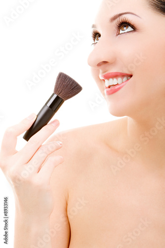 Pretty young woman with a make-up brush