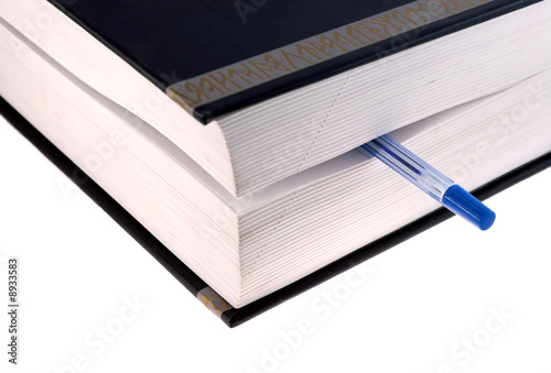 Book with pen on white