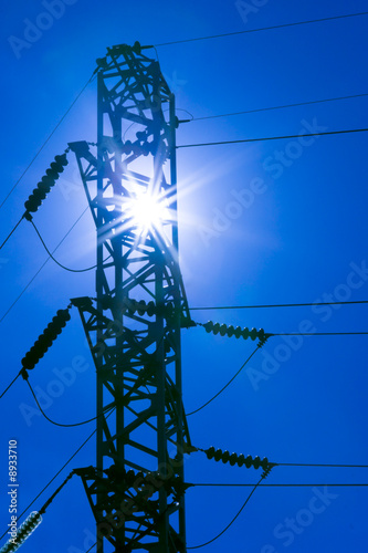 Rays of sun in pylon of electrical power transmission line