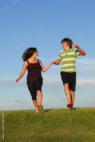 A young couple frolicking on hillside
