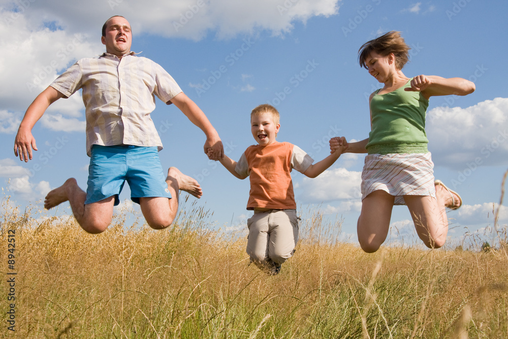 happy family jumping together on a summer day happy family jumping together on a summer day
