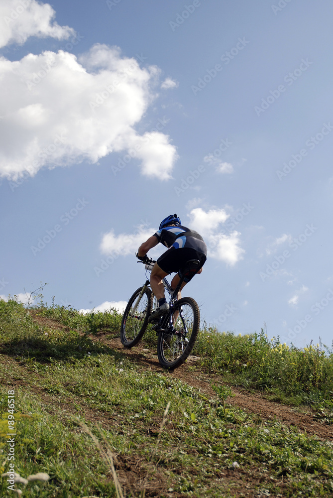 Bicyclist on a background blue sky