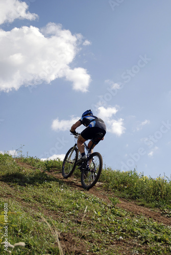Fototapeta Naklejka Na Ścianę i Meble -  Bicyclist on a background blue sky