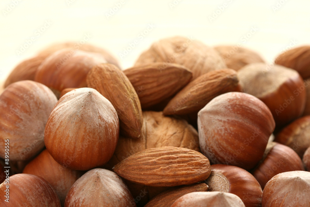 close-ups of hazelnuts and walnuts on wooden table close-ups of hazelnuts and walnuts on wooden table