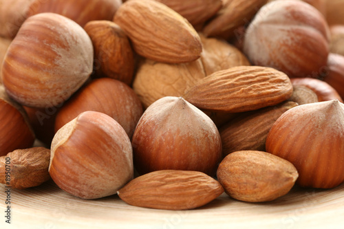 close-ups of hazelnuts and walnuts on wooden table
