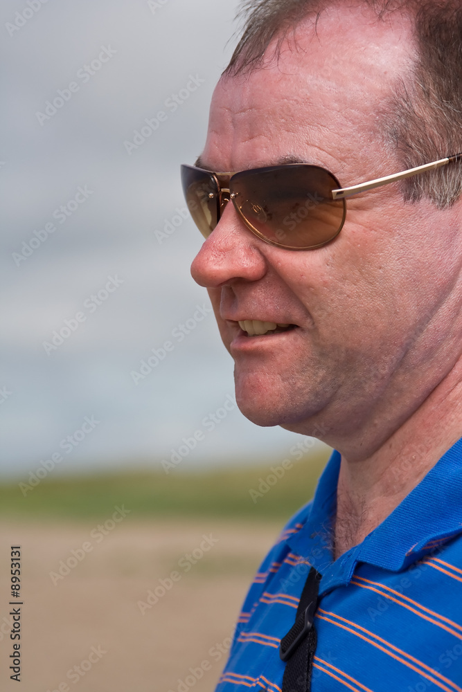 Middle aged man enjoying a walk on the beach Middle aged man enjoying a walk on the beach