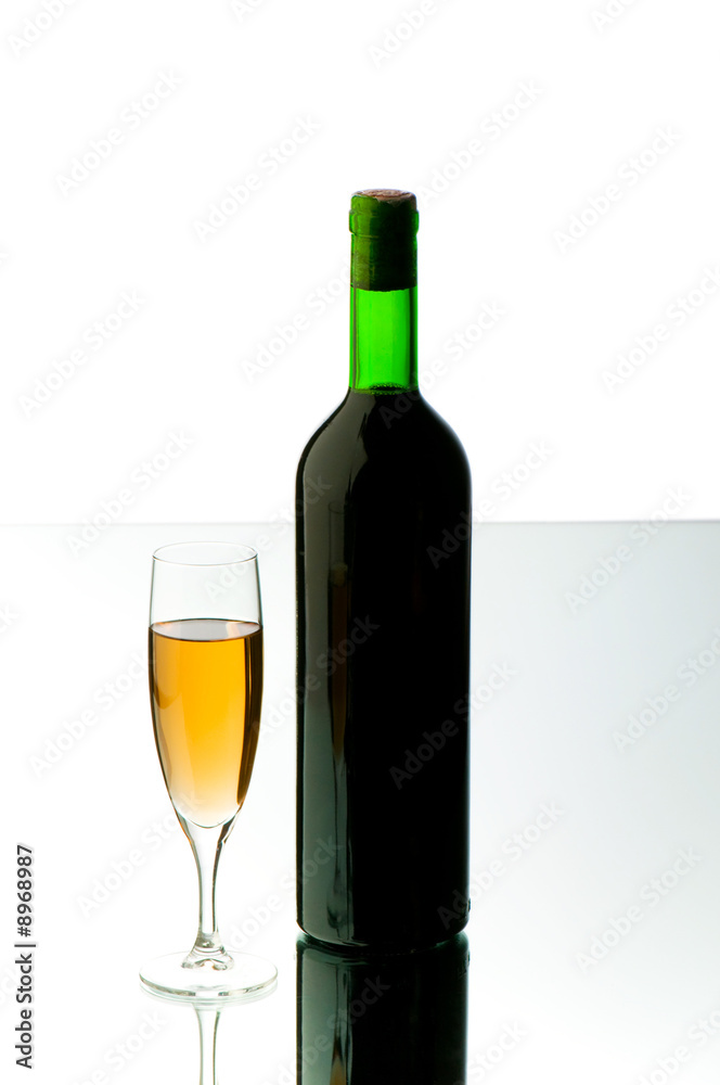 Bottle and wine glass on reflective background