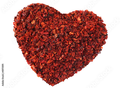 Red chili pepper in heart pepper on white