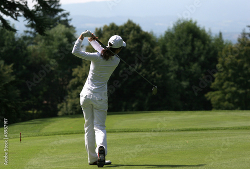 Woman on golf course at swing