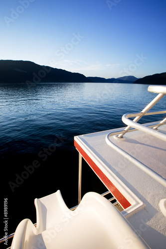 A slide off a luxury yacht into a beautiful lake at sunset