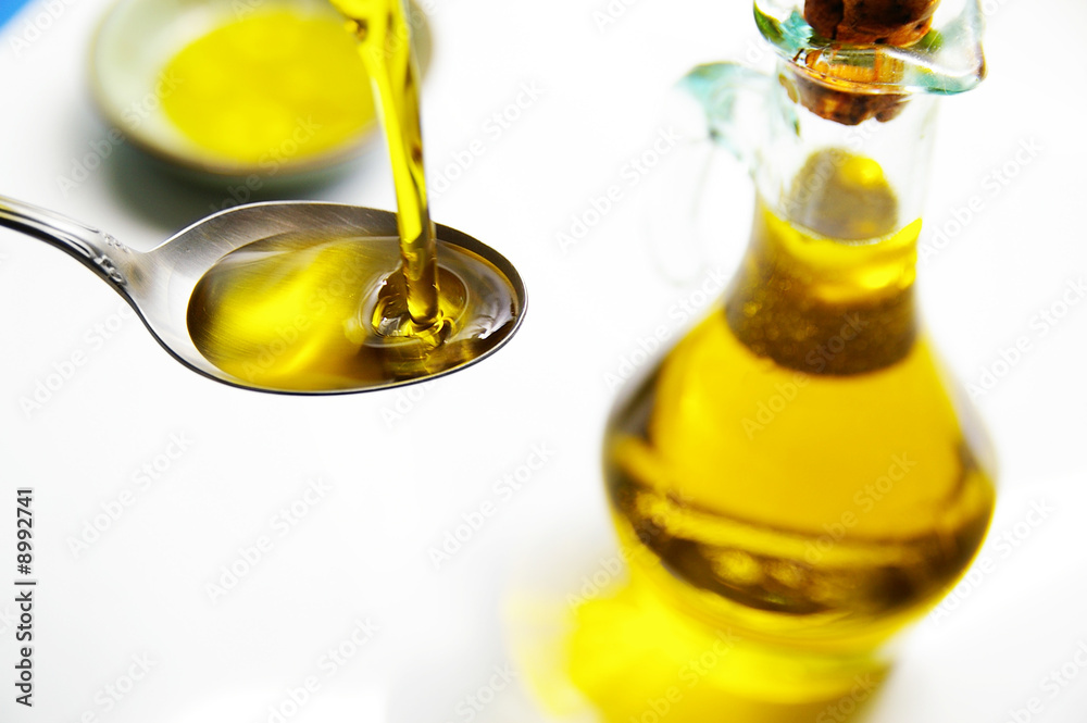 olive oil being poured into a spoon olive oil being poured into a spoon