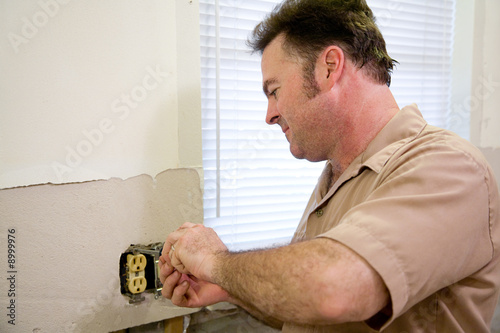 Canvas Print Electrician repairing an electrical outlet.