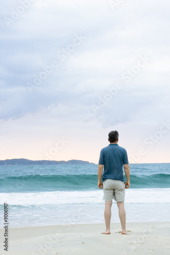 Mann steht am Strand und betrachtet das Meer © ArtmannWitte
